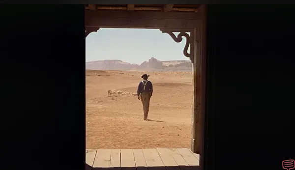A lone cowboy walks into the desert from a darkened doorway.