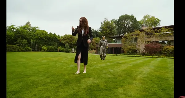Two people in a garden with a modern house in the background.