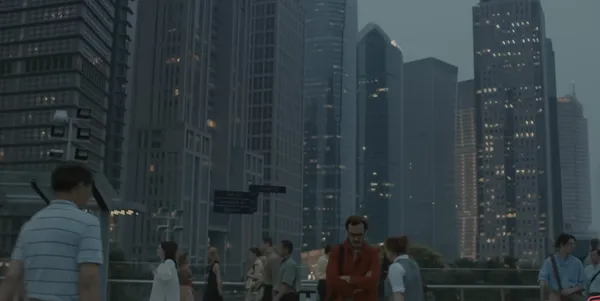 People walking on a city street with skyscrapers in the background.