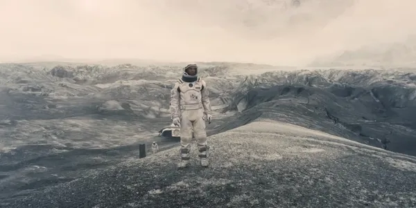 Astronaut standing in a desolate, alien landscape.