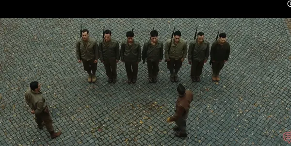 A group of soldiers standing in formation being addressed by two men.