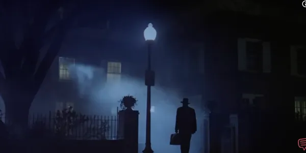 A silhouetted figure under a streetlamp in a foggy, eerie setting.