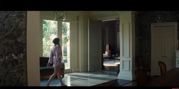 A person walking in a well-lit interior space with large windows.