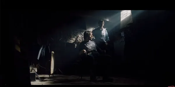 A dramatic and tense interaction in a dimly lit room.