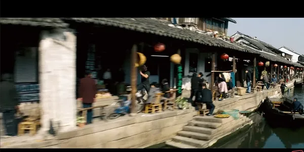 A bustling riverside market scene in an old town.