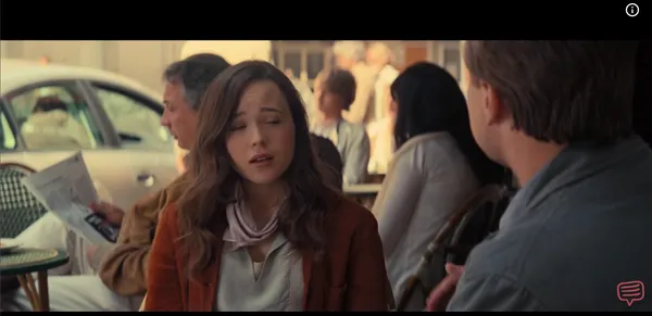A young woman speaking intensely in a bright outdoor cafe
