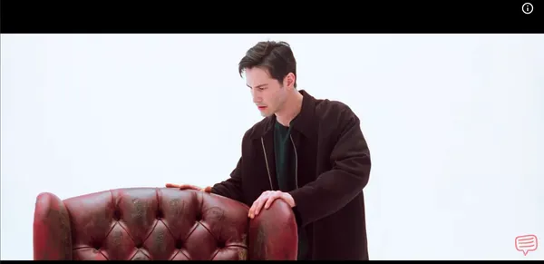 A confused man touching an antique red leather chair in a blank white room