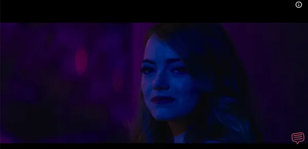 A woman looking warmly with tearful eyes bathed in purple club lighting