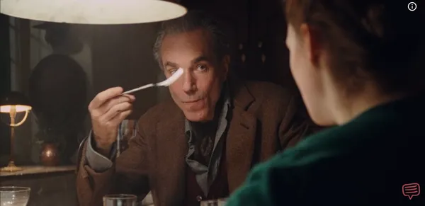 A man carefully evaluating a bite of food on his fork while looking at his companion