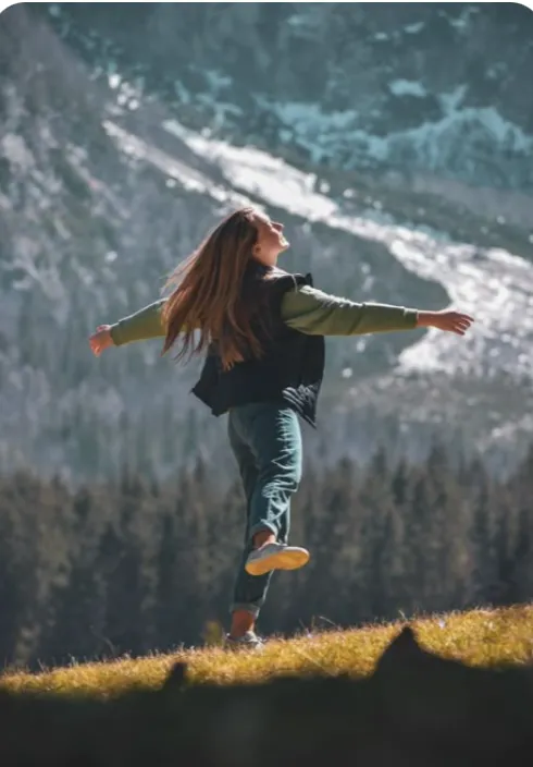 Person enjoying nature with a mountain backdrop
