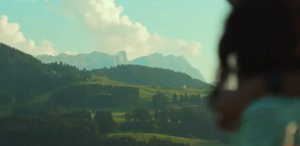 A scenic view of mountains with a blurred foreground person.