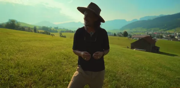 A person standing in a scenic rural landscape.