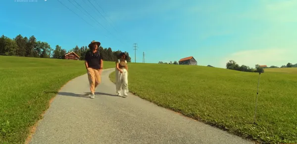 Two people walking on a countryside path.