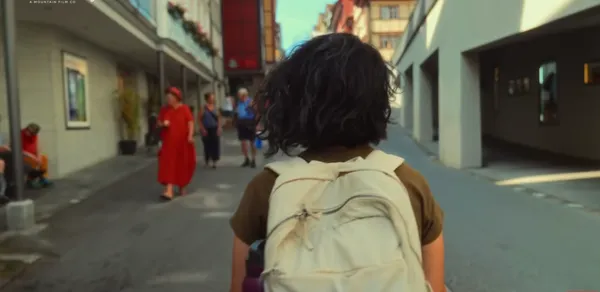 Person walking down a street with people around.