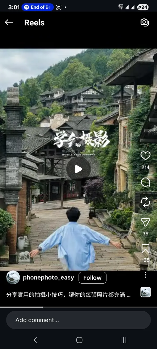 A person walking towards a rustic village setting.