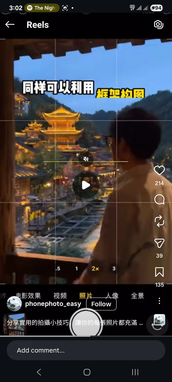 A person observing a traditional building at dusk.