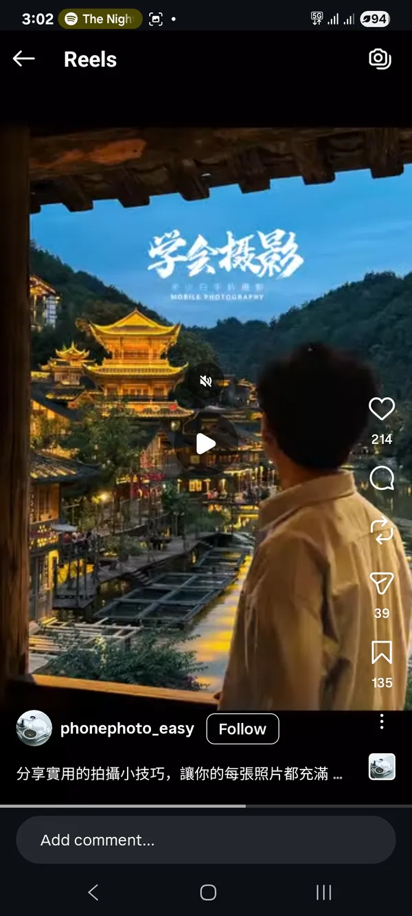 Person overlooking a beautifully lit traditional village at dusk.