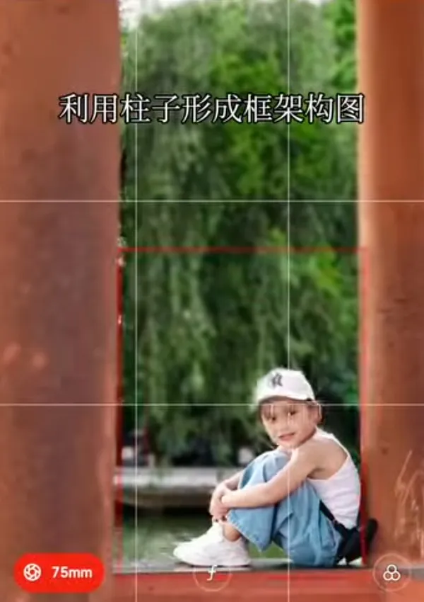 A child sitting framed by pillars in an outdoor setting.