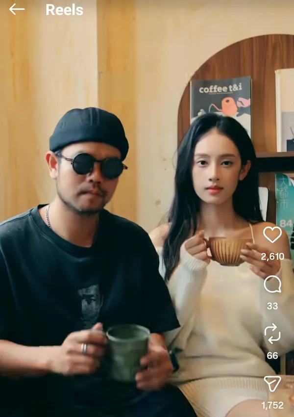 Two people sitting indoors holding mugs.