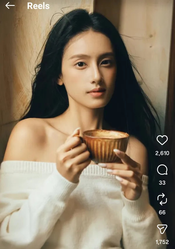 A person holding a cup in a cozy indoor setting.