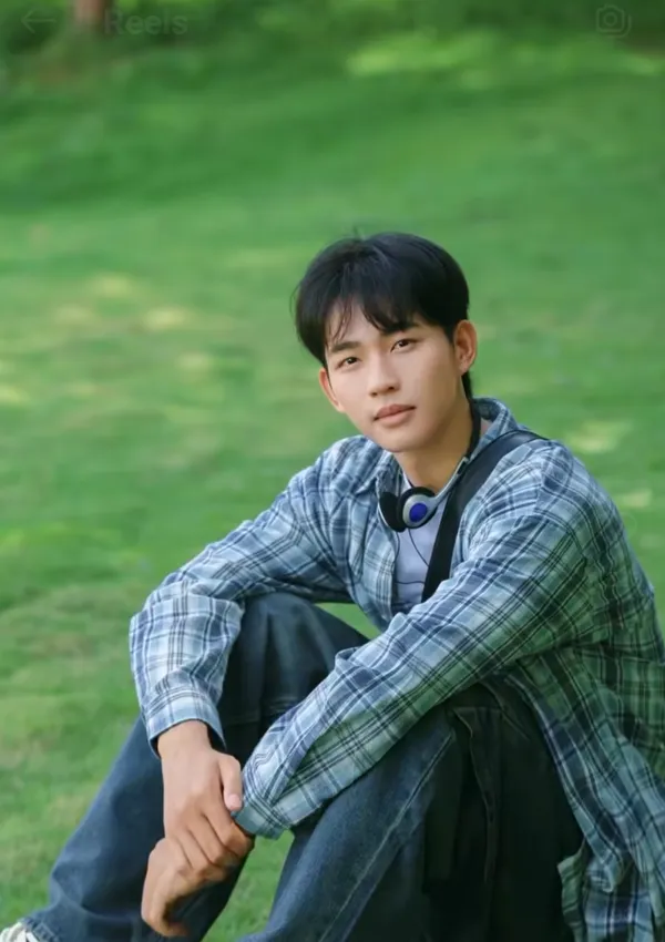 A person sitting on grass in a relaxed pose.