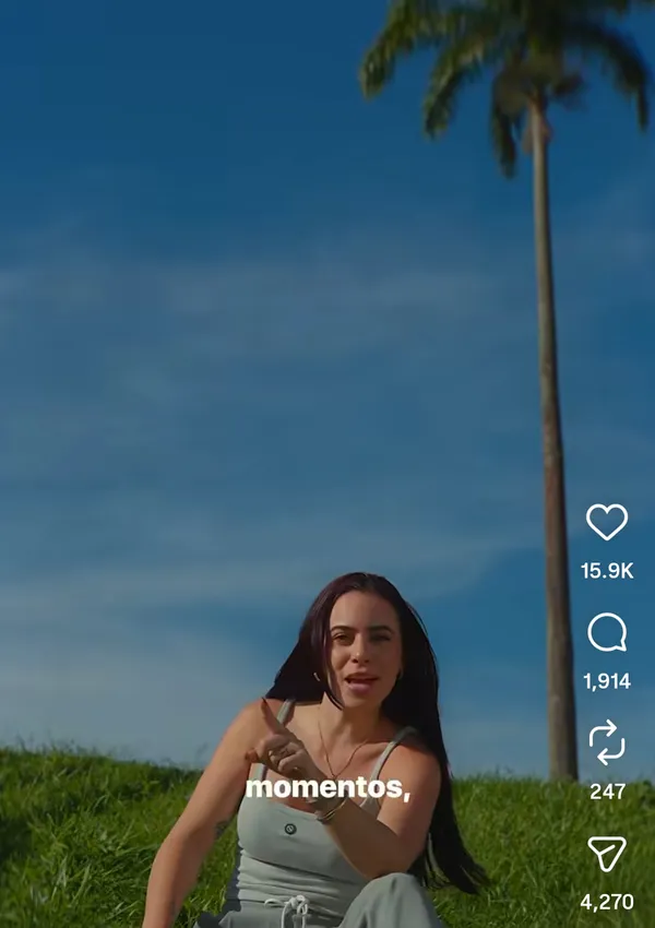 A person sitting on grass with a palm tree in the background.