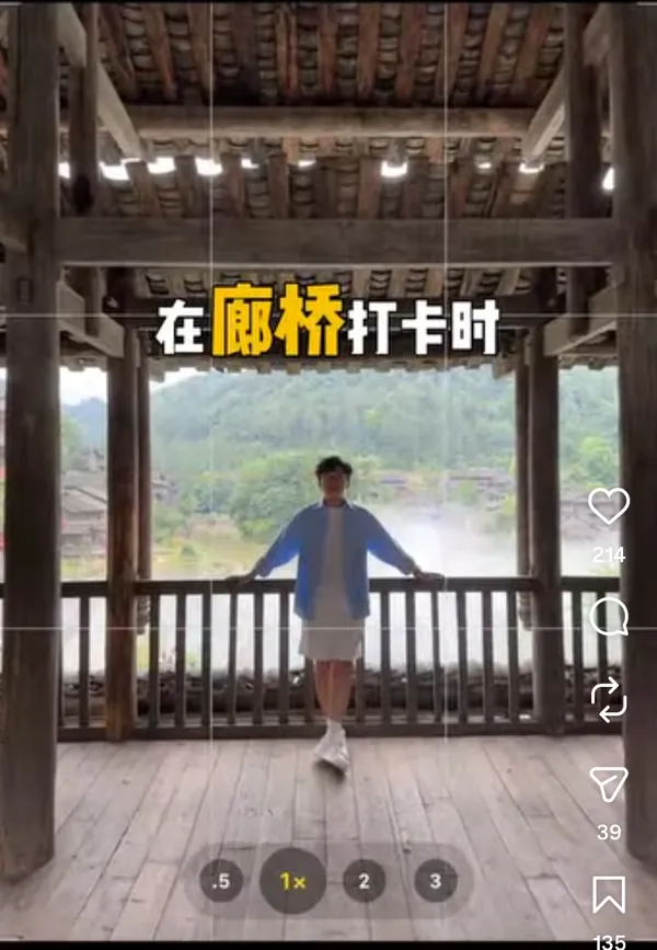 Person leaning against a wooden railing with a scenic mountain view in the background.